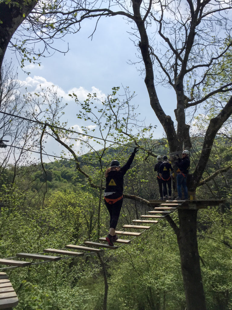 Crossing a rope bridge at Jungle Raider Park Como