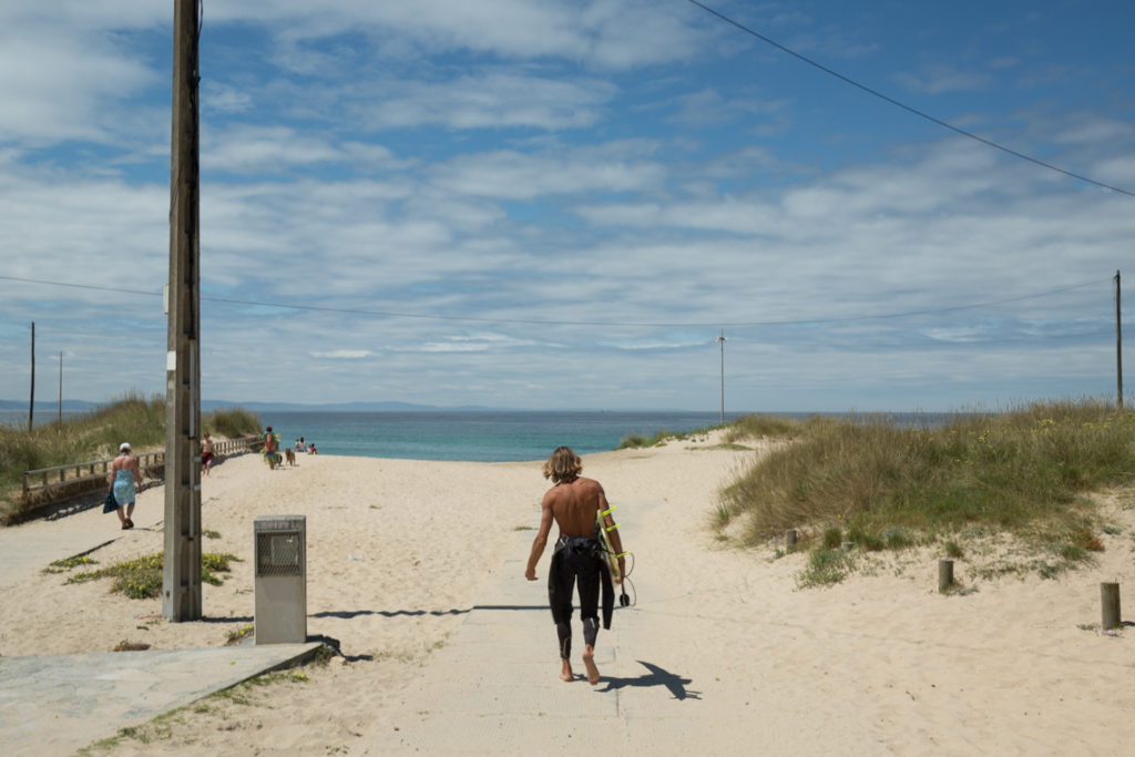 Surfer heading to the beach Praia de Doniños
